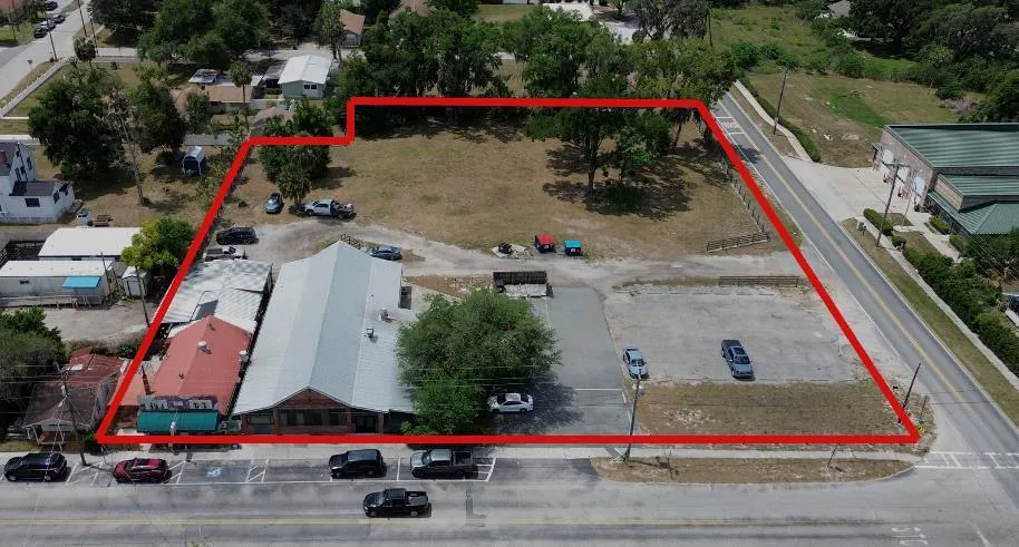 Aerial image from the offering memorandum with the four-parcel property boundary outlined in red